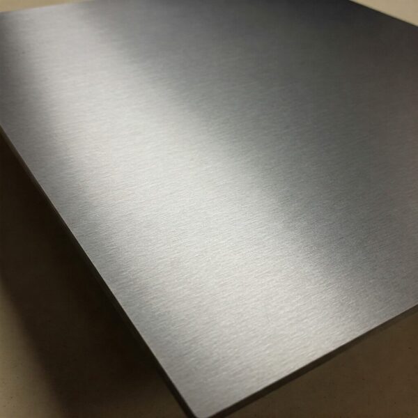 Plat stainless steel 3CR12 dengan finishing brushed, ideal untuk aplikasi industri dan konstruksi.
